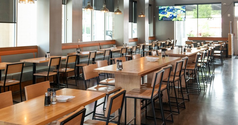Interior, high seating area, wooden tables and chairs, concrete flooring