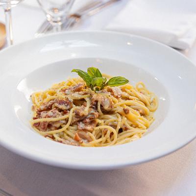 Spaghetti Carbonara garnished with fresh basil.
