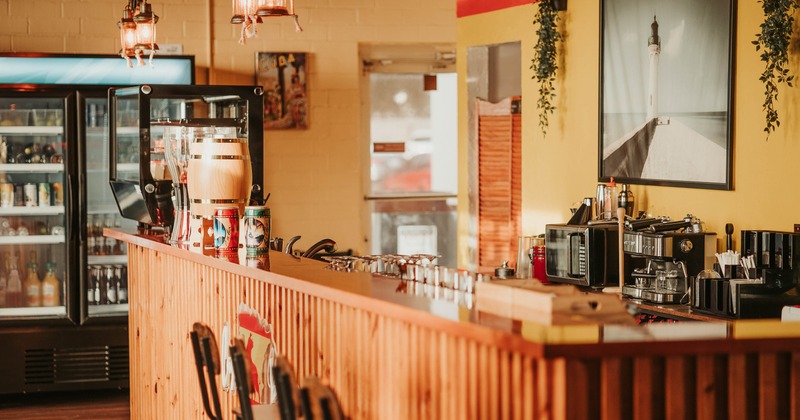 Interior, bar area, wooden top bar with stools, appliances in the back