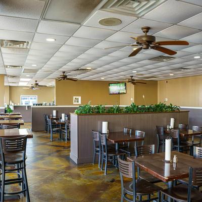 Interior with tables, chairs, ceiling fans, and a TV.
