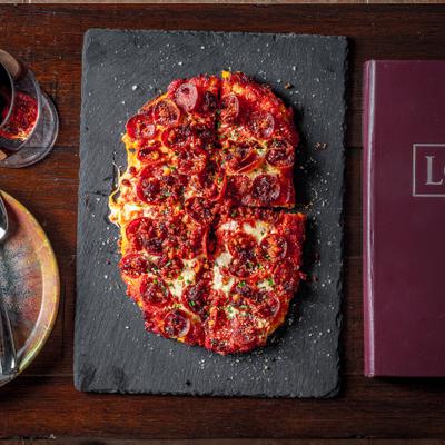 Italian meat flatbread with melted cheese and herbs.