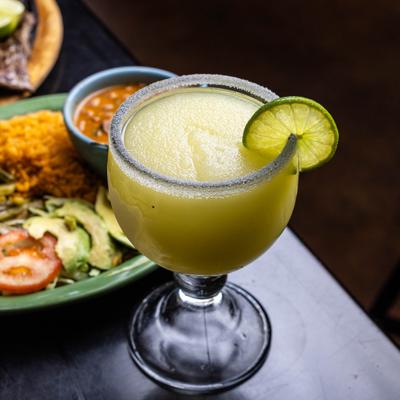Frozen margarita served in a classic margarita glass with a lime wheel garnish.