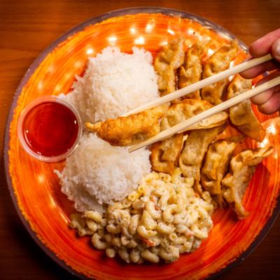 Dumplings with rice, sweet chili sauce, and mac and cheese.