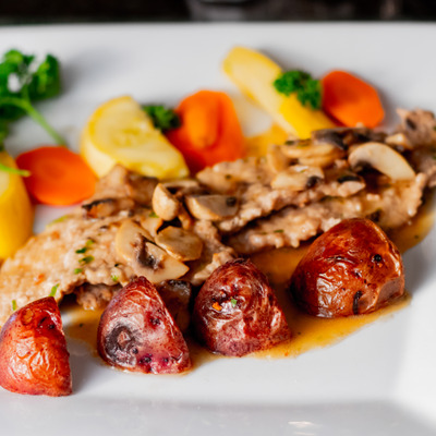 Meat with potatoes, carrots, sauce and greens.