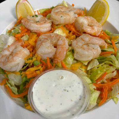 Shrimp salad with shredded lettuce, carrots, and a side of dressing.