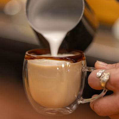 Milk being poured into a cup of coffee.