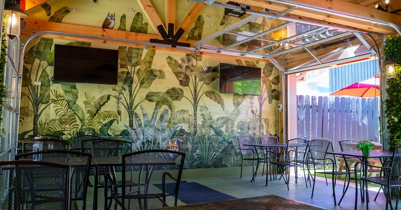 Interior, seating area, tables and chairs, TV screens on the wall