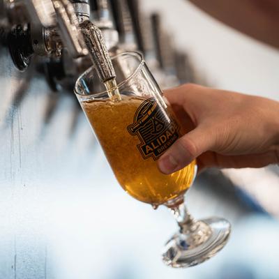 A hand pouring beer from a tap.