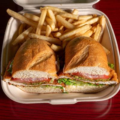 A takeout box holds Crispy Chicken Sandwich with French Fries.