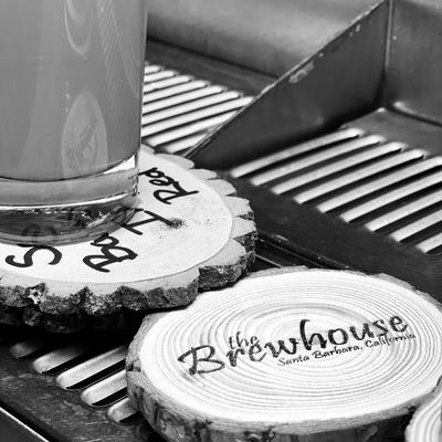 Live edge wood coaster with The Brewhouse printed on it.