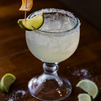 Margarita cocktail served in a rimmed glass, garnished with a lime wedge.