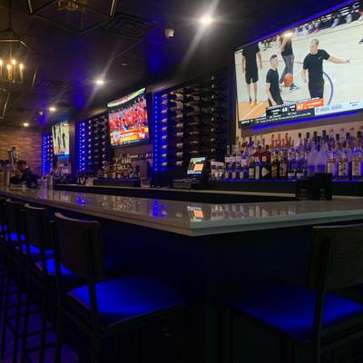 Interior, bar with wine racks on the wall and bar chairs