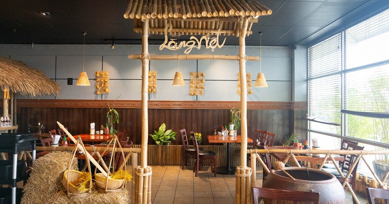 Cozy restaurant interior with bamboo decor, haybales, and wooden furniture