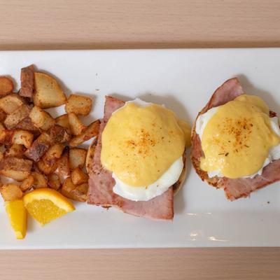 Ham Eggs Benedict, served with home fries.