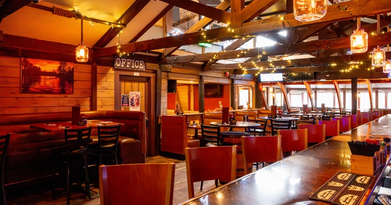 Interior, bar area, wooden top bar with stools, high and regular seating area in the back