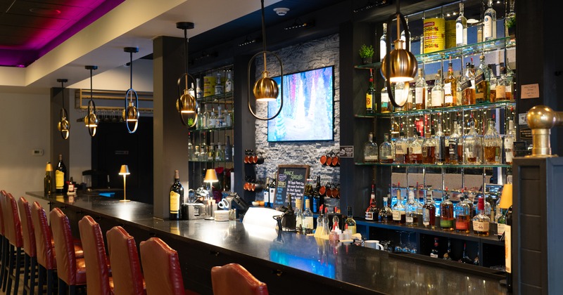 Bar, chairs, drink rack, tv screen above