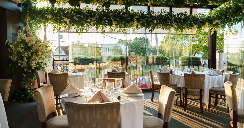 Interior decorated with plants, tables ready for guests