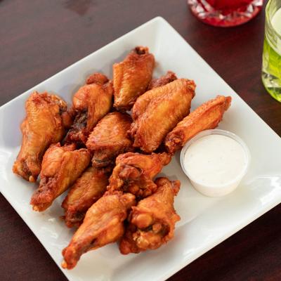 Fried chicken wings with dip on the side.