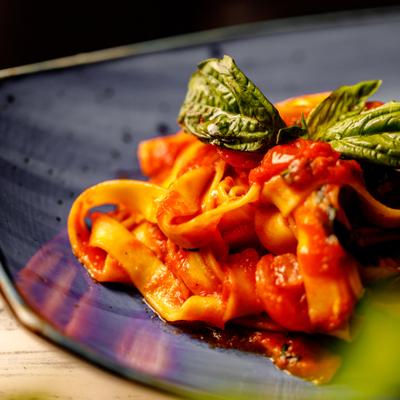 Pasta in tomato sauce, garnisheed with fresh basil, close-up.