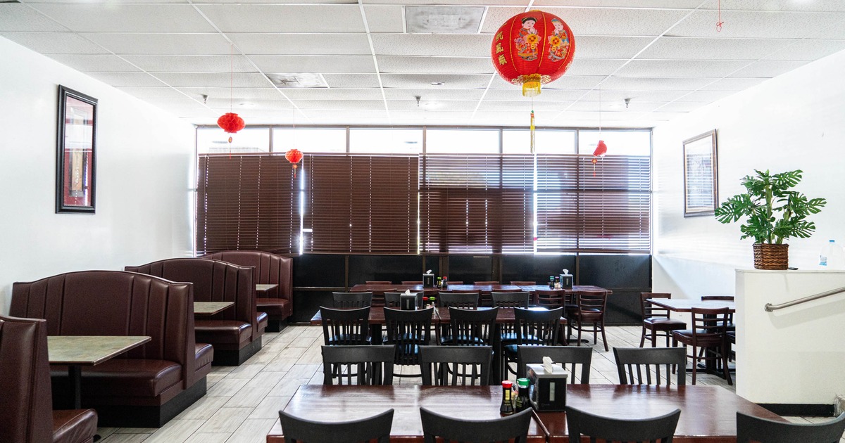 Interior with a mix of booth and table seating, potted plants and red lanterns