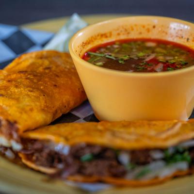 Birria Tacos with consomme, close-up.
