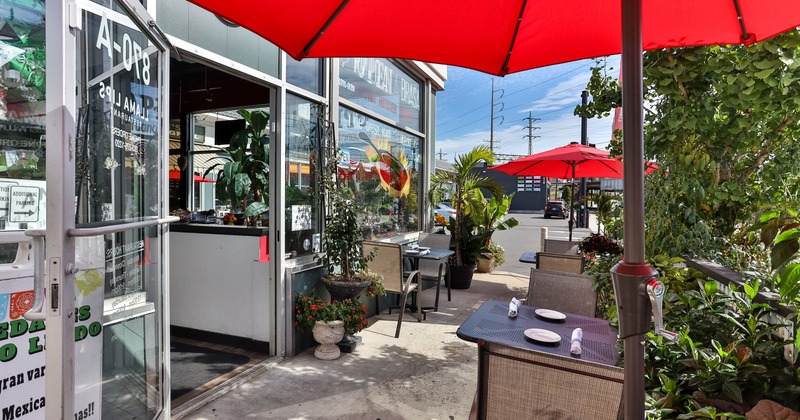 Outdoor dining area in front of the entrance, tables set for two guests