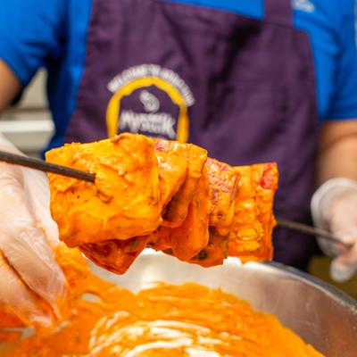 A chef preparing Paneer Tikka.