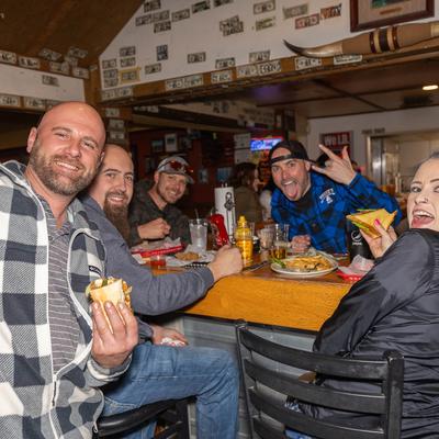 A group of customers enjoying food and drinks at a table.