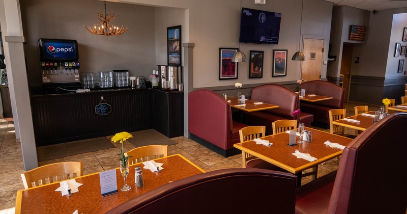 Cozy dining area with upholstered booths, tables and chairs
