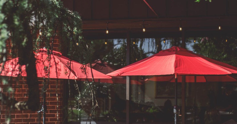 Exterior, side walk patio, tables, chairs, entrance, sign