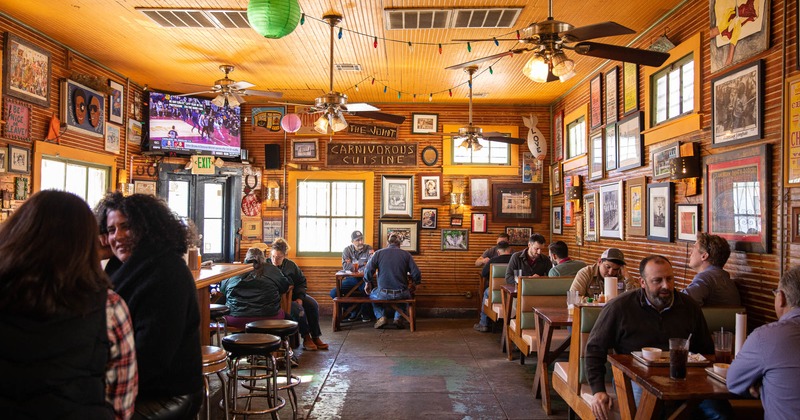 Interior, wide view, guests chatting and enjoying their food and drinks