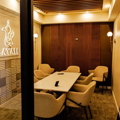 Meeting room featuring beige chairs around a rectangular table, and a logo on the wall.