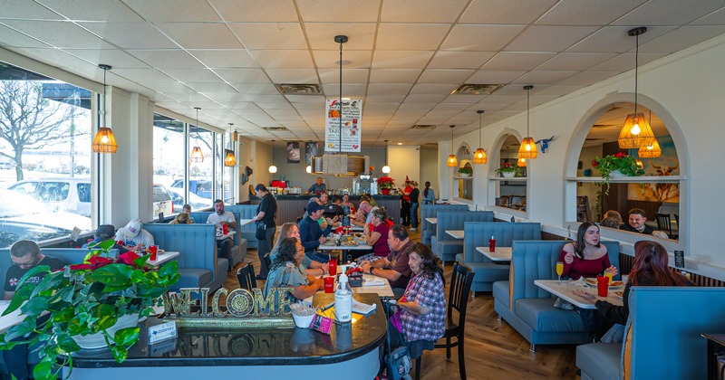 Spacious and cozy interior dining area full of guests enjoying their food and drinks