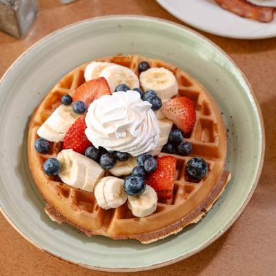 Waffle with banana, berries, and whipped cream.
