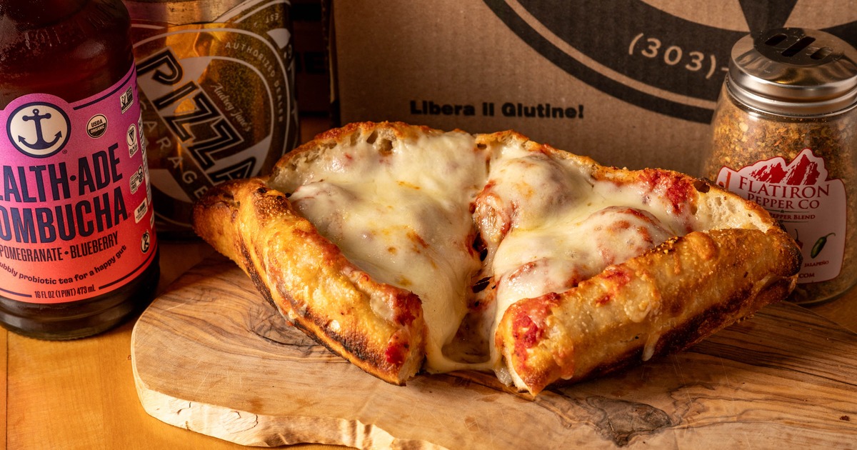 Cheesy folded pizza served with kombucha and red pepper flakes