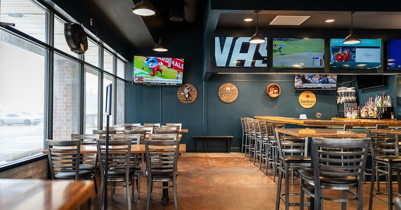 Sports bar interior seating area, TV sets on the wall