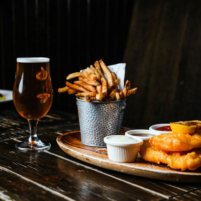 Fish and chips plate, accompanied by a glass of beer.