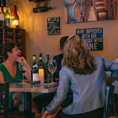 People sharing wine at a cozy restaurant table.