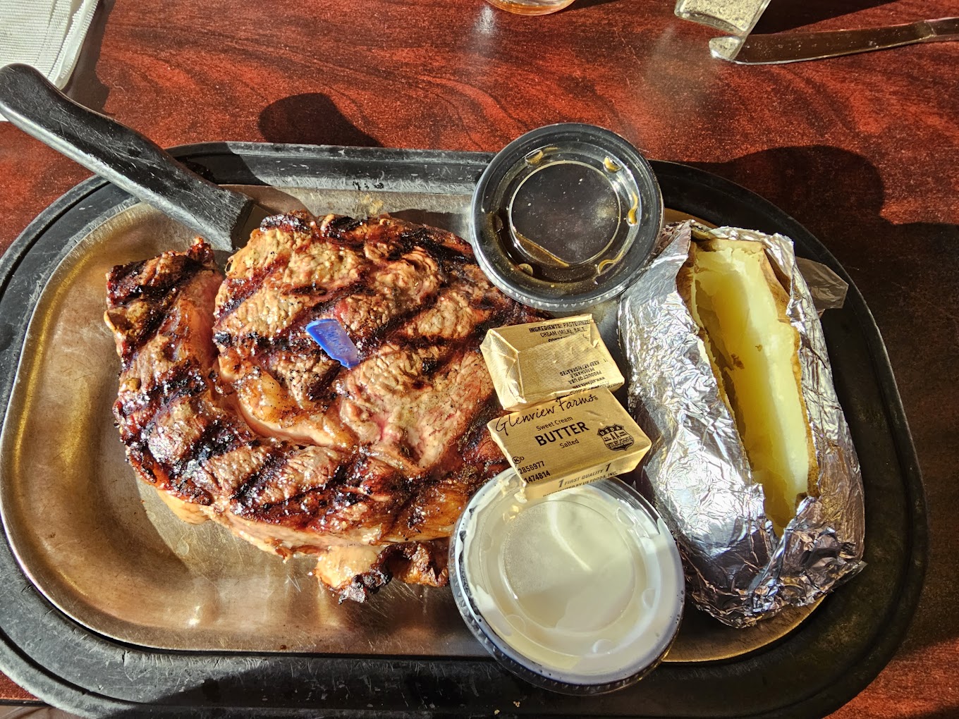 Grilled chicken, baked potato, and butter