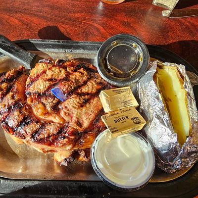 Grilled chicken, baked potato, and butter.