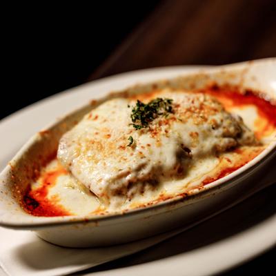 Baked lasagna served in a traditional oval ceramic dish.