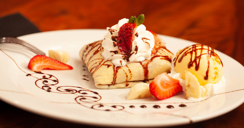 Crepe with whipped cream, strawberry, banana and ice cream on the side