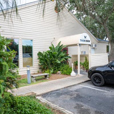 Storefront with signage and lush greenery.