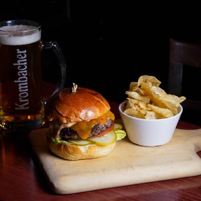 La Cava Burger served with fries, alongside a mug of beer.