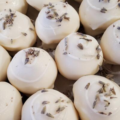 Close-up of smooth white truffles, topped with dried lavender buds.
