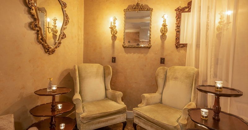 Antique interior, two armchairs and antique mirrors on wall