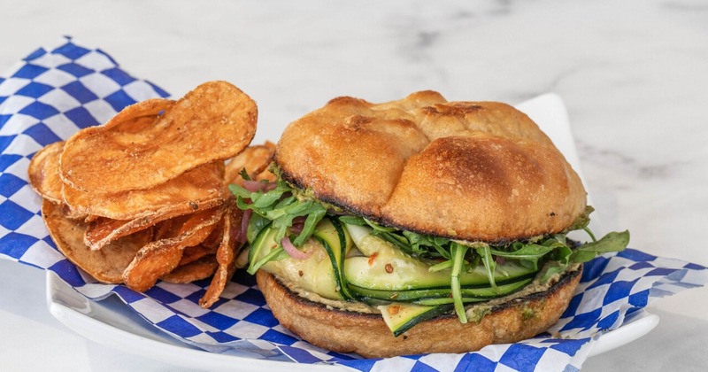 Sandwich with green vegetables, served with chips