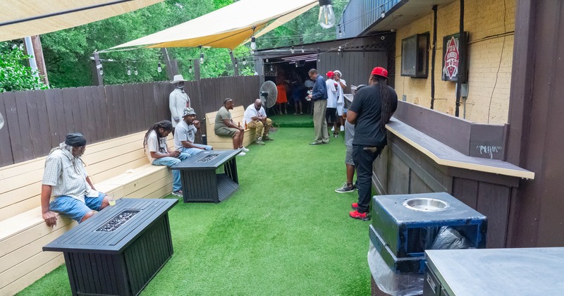 Outdoor bar patio with artificial grass and shade sails