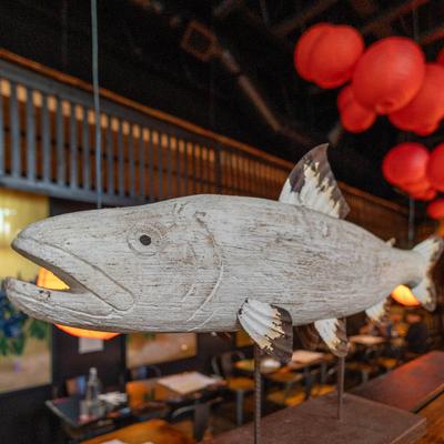 A rustic wooden fish sculpture.