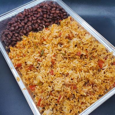 Catering tray filled with  jollof rice and black beans.